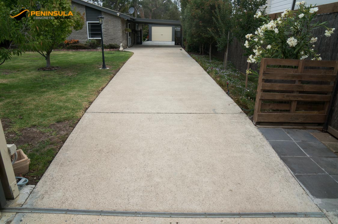 Tired exposed aggregate driveway surface before driveway painting assessment